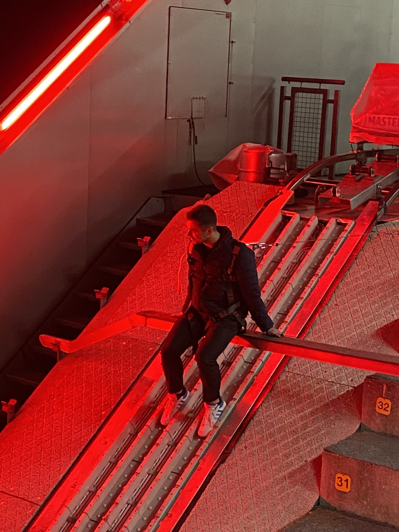 Person on red-lit industrial structure at Hybriqe 2024